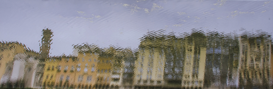 A photo of a blurry window, presumably caused by rain, overlooking a city street with buildings